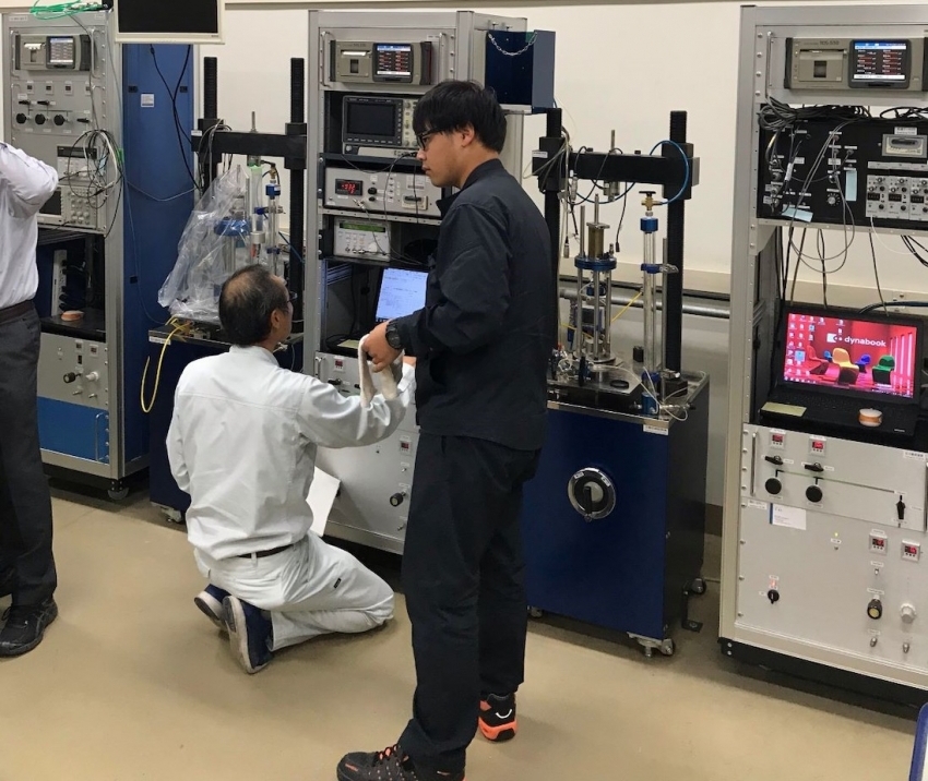 令和元年10月25日、多田健君（平成26年入社）は、香川高専の三軸試験機の前で試験の手順を説明しています。