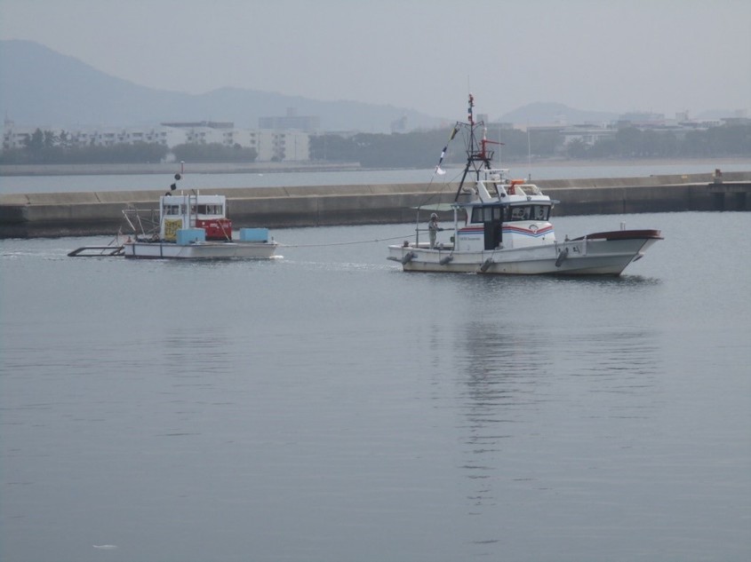 磁気探査台船と曳き船による曳航状況